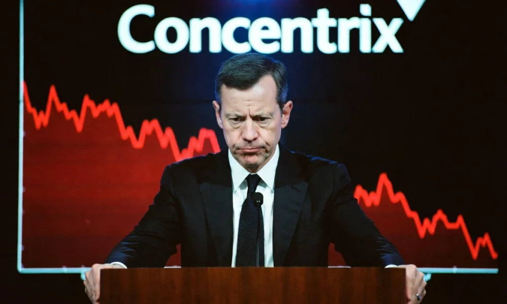Concentrix CEO at earnings call podium with stock chart screen behind